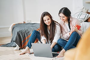 Two college students looking at something on a laptop