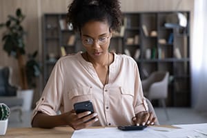 African American woman manage finances using cellphone