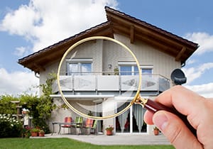 Magnifying glass in front of a home help by someone